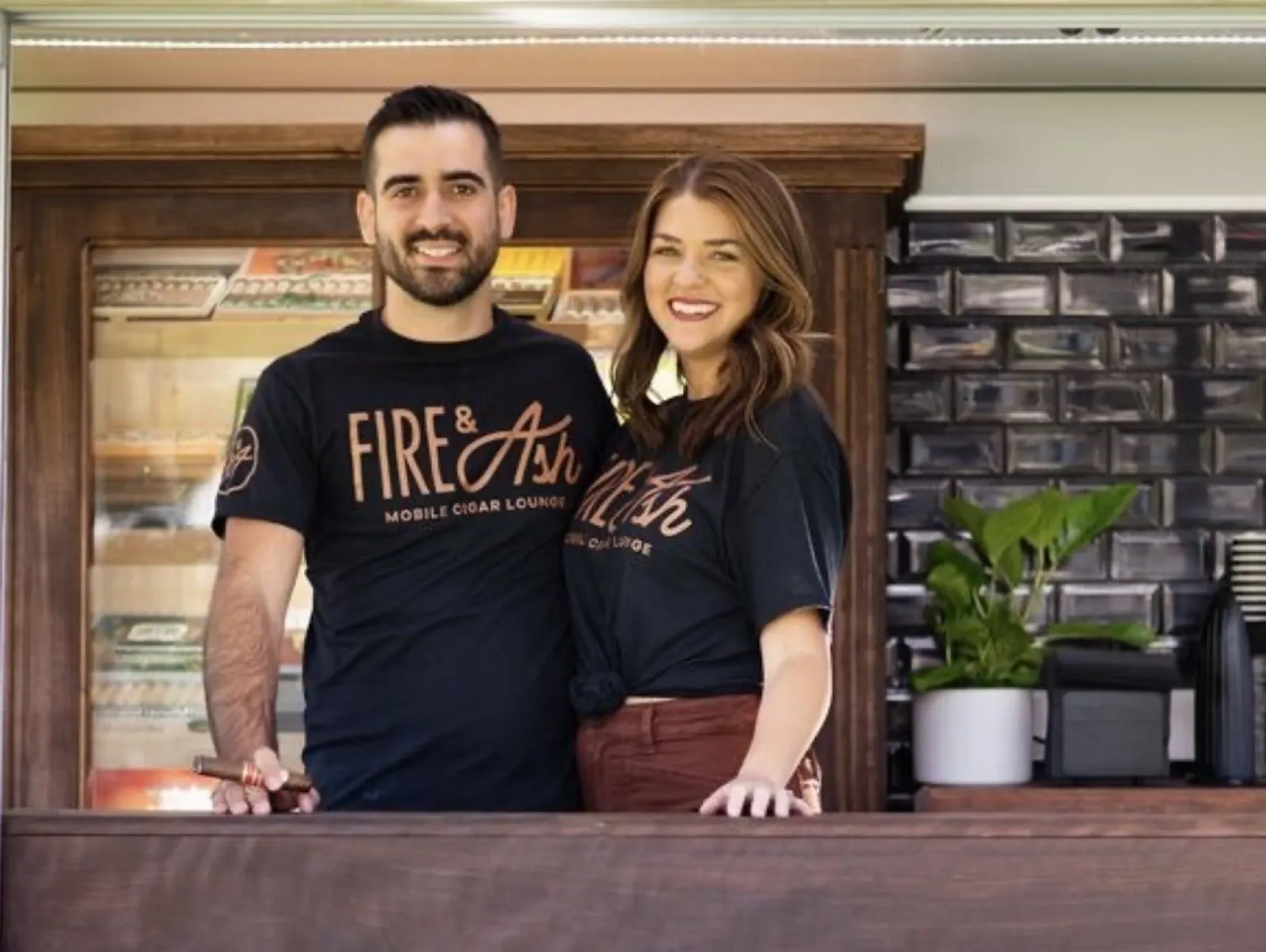 Carlos and Hannah Lopez in Fire and Ash shirts at the cigar truck window