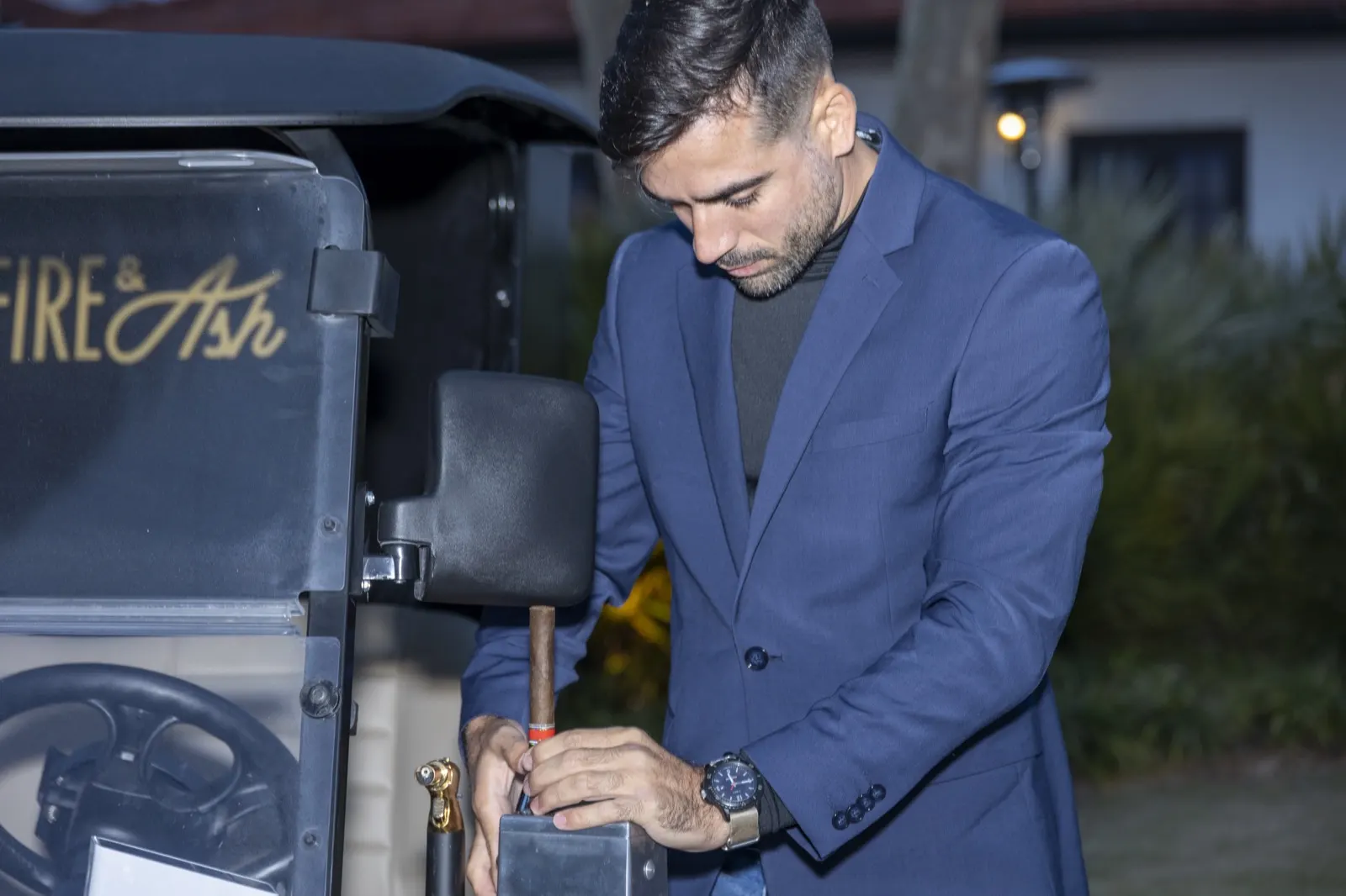 Attendant serving cigars from the golf cart at twilight