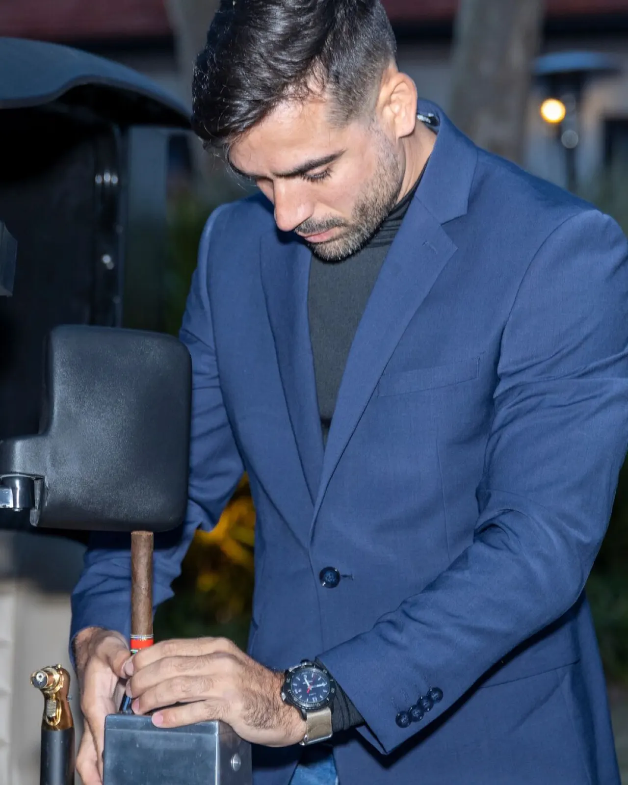 Hands cutting and preparing a premium cigar with a torch lighter