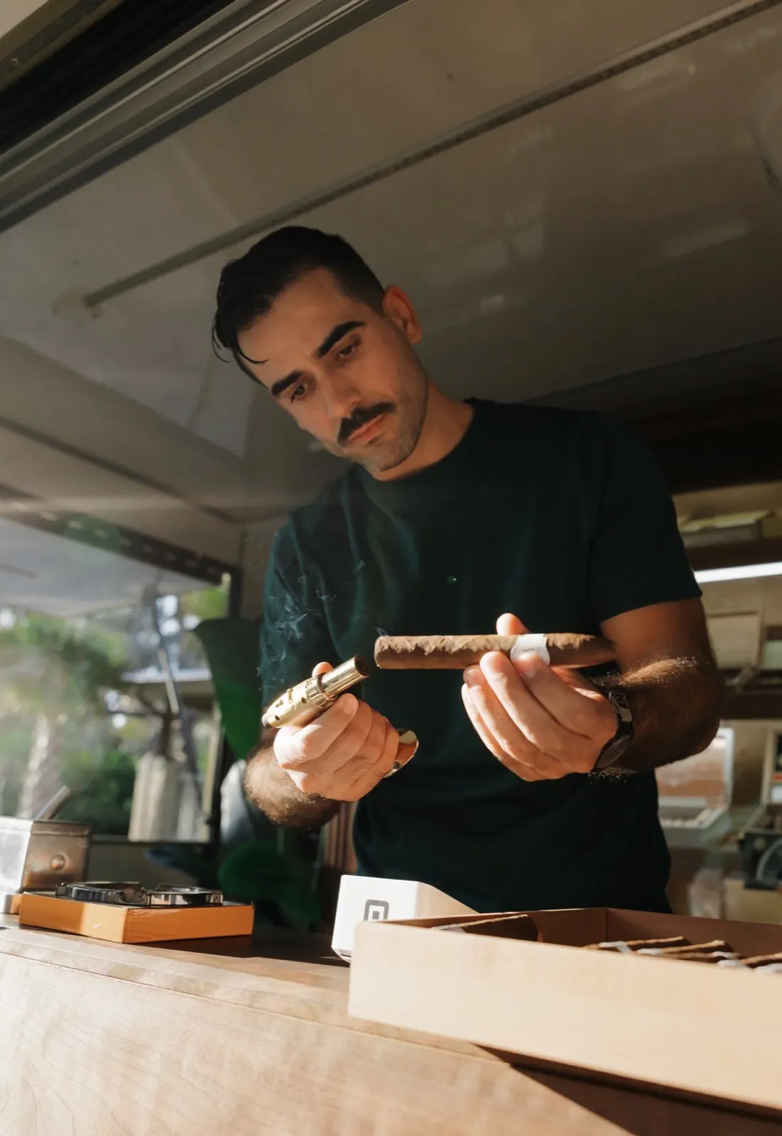 Attendant presenting a cigar selection tray to guests