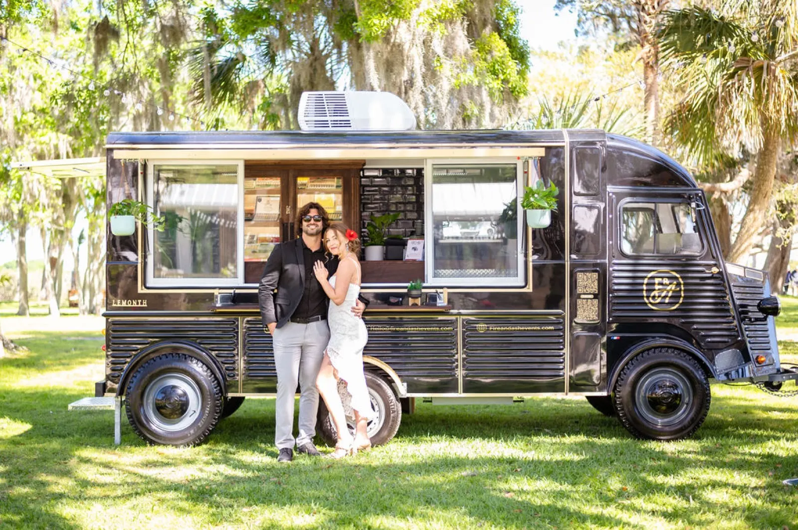 Newlyweds posing with the vintage Fire and Ash cigar truck