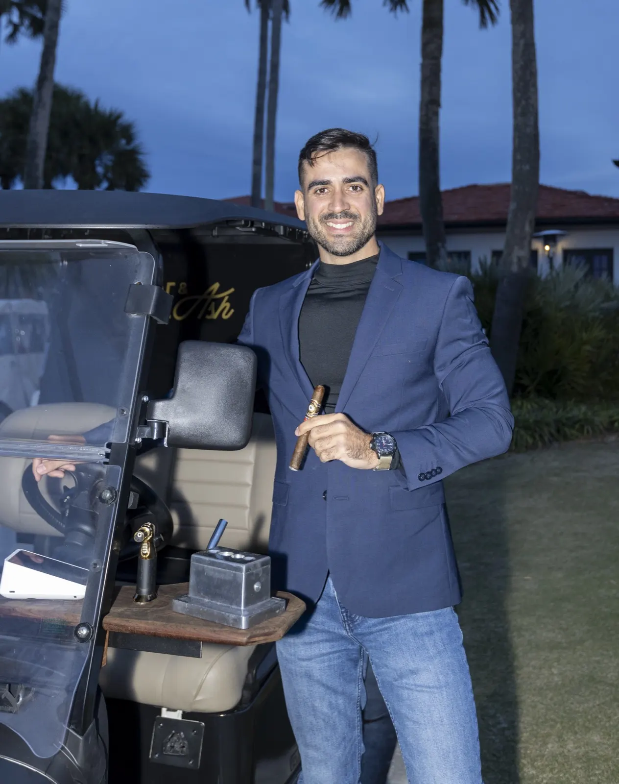 Founder Carlos Lopez beside the cigar golf cart at dusk