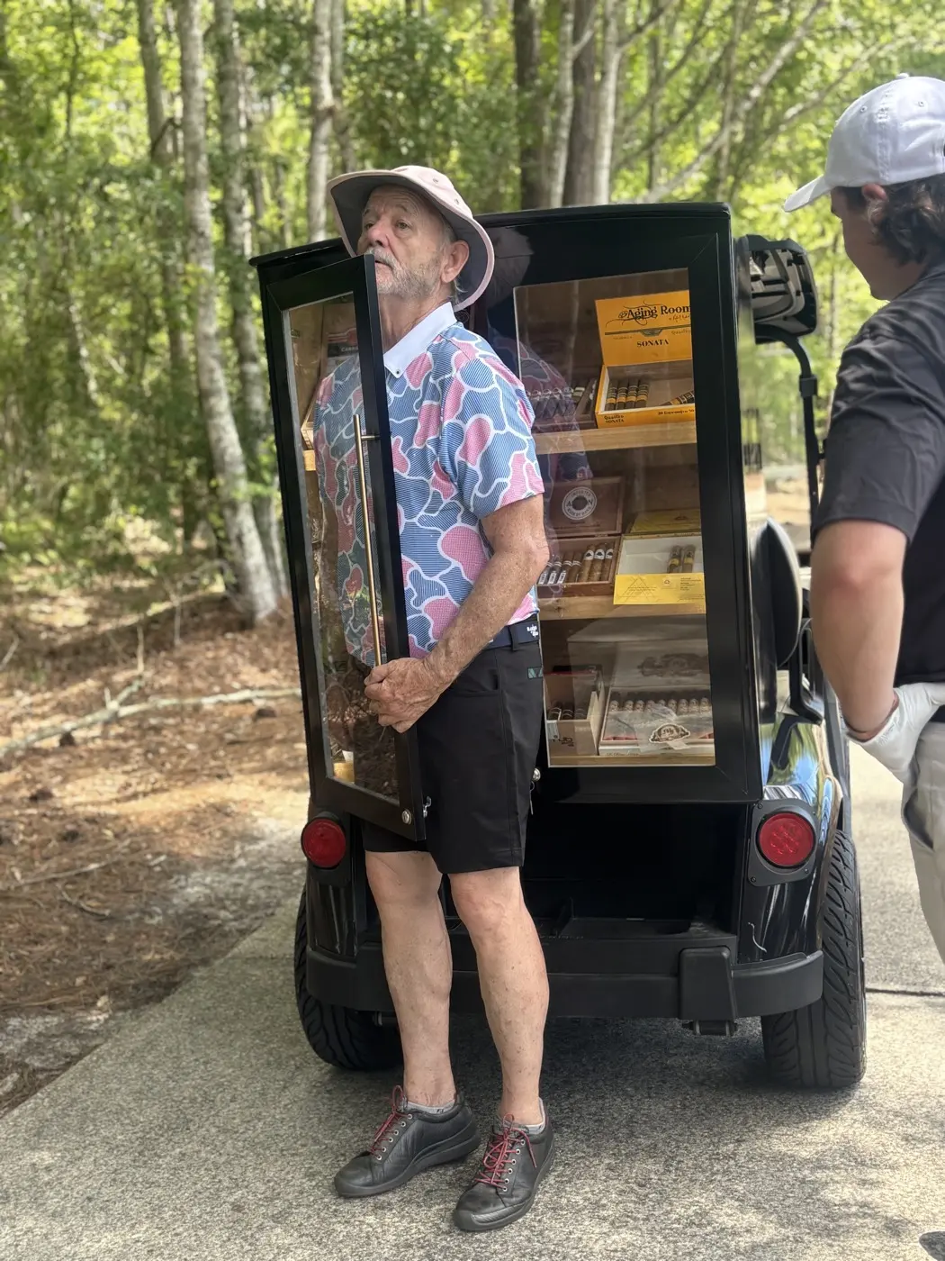 Guest browsing the Fire and Ash cigar cart in the woods