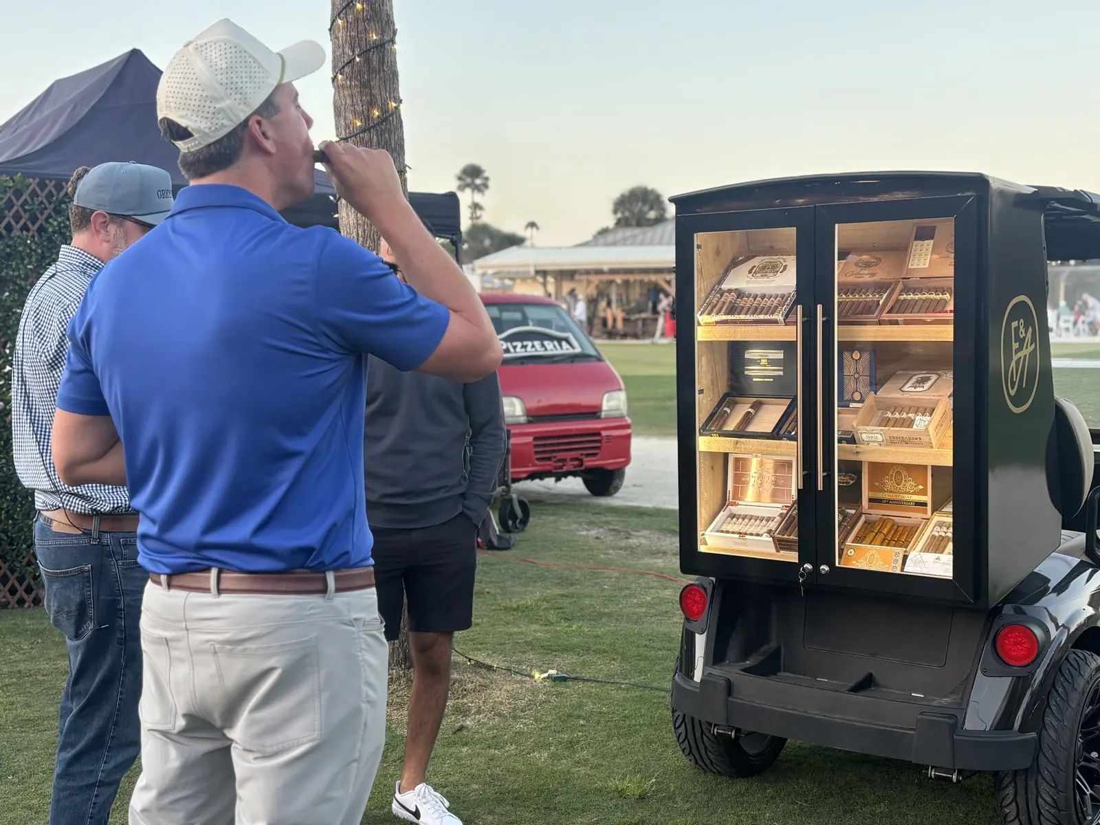 Golfers taking a cigar break by the cart