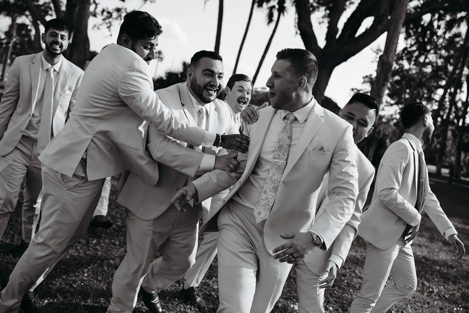 Groomsmen celebrating together in black and white
