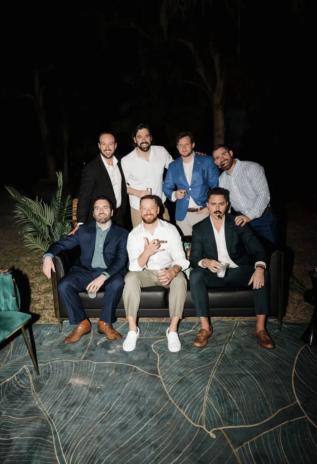 Groomsmen seated on the lounge couch with cigars