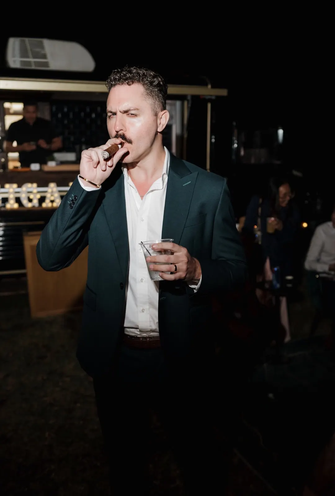 Guest in a green jacket enjoying a cigar