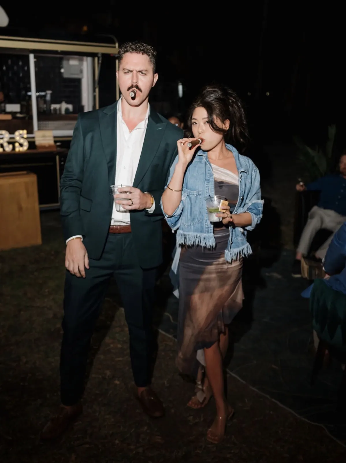 Wedding guests mingling with cigars at the reception
